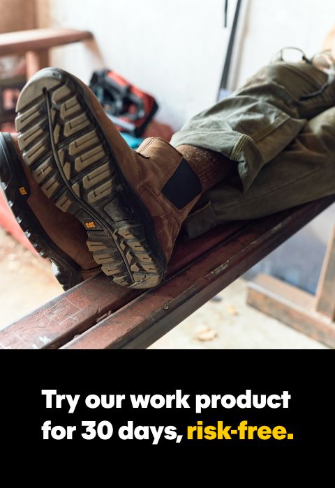 Feet wearing boots on a piece of iron box.