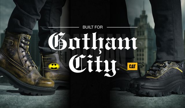 Feet wearing Batman x CAT footwear standing on a high ledge overlooking Gotham.