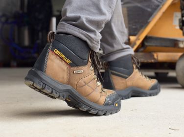 Brown boots walking toward machinery.